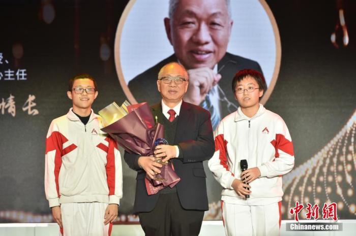 中国人民大学附属中学的两位同学为丘成桐献上奖杯，致敬杰出的华人数学家。/p中新社记者 翟璐 摄